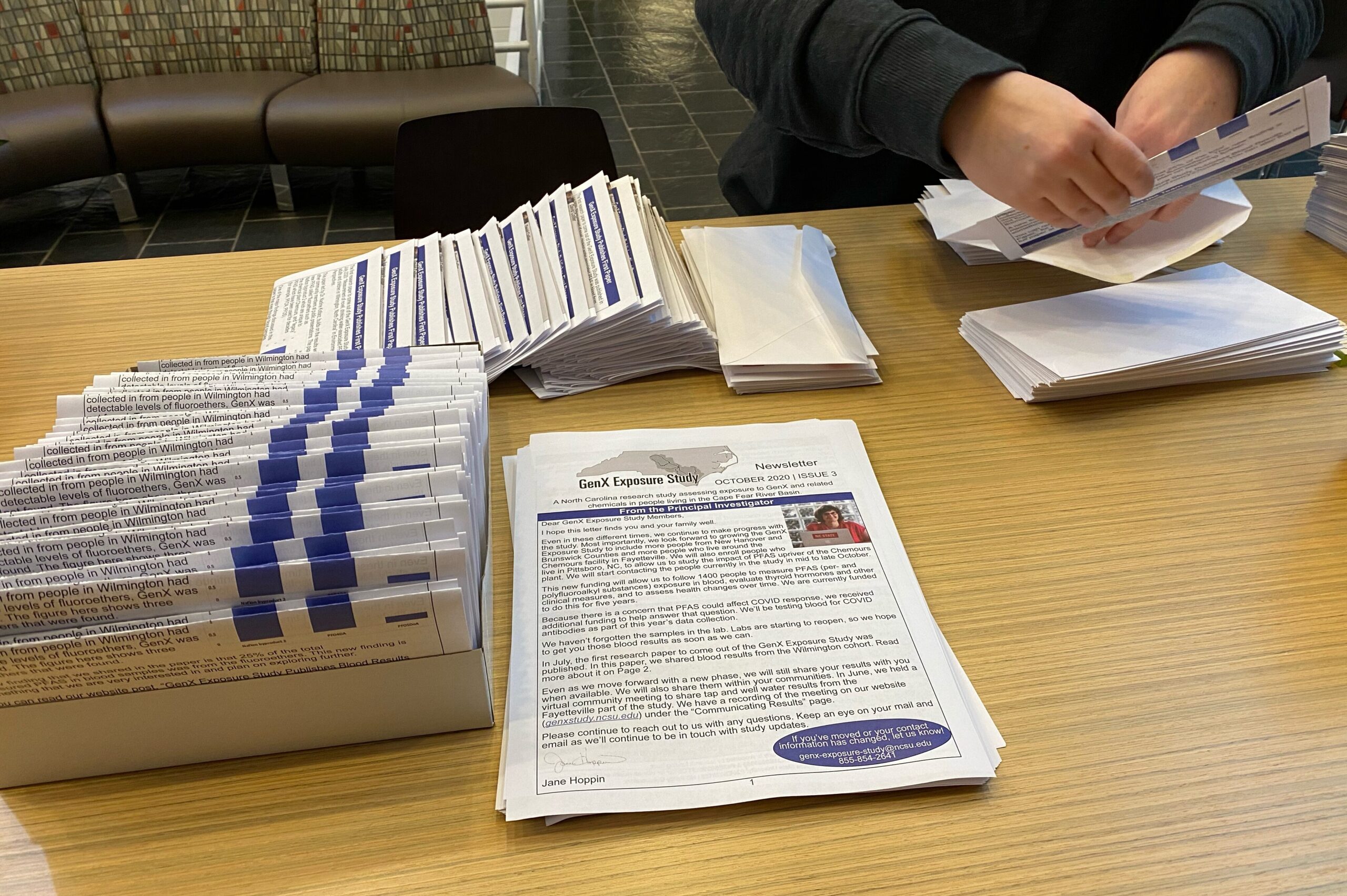 Newsletters being folded and packed into envelopes. 